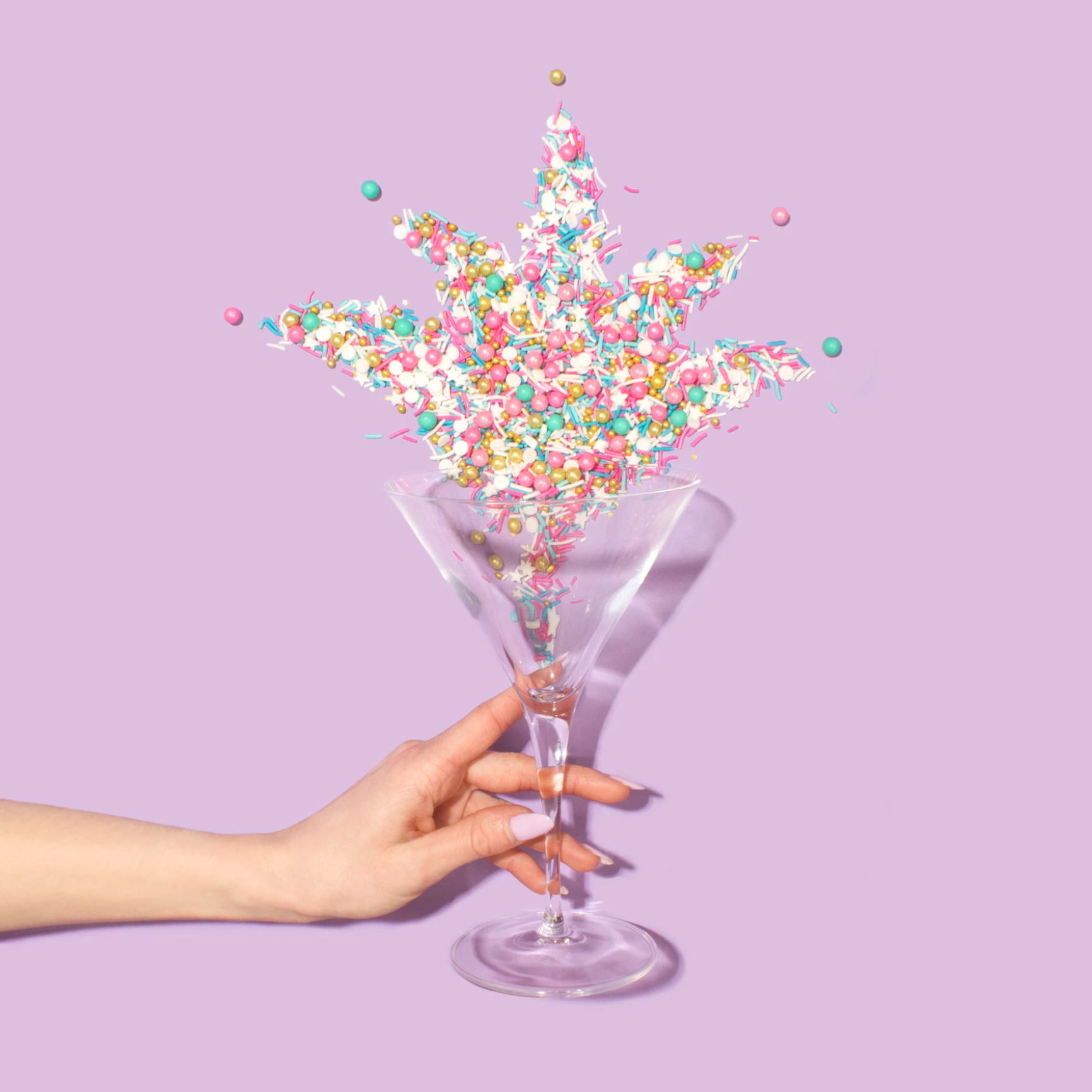 Hand throwing upwards a wine glass of Sprinkles